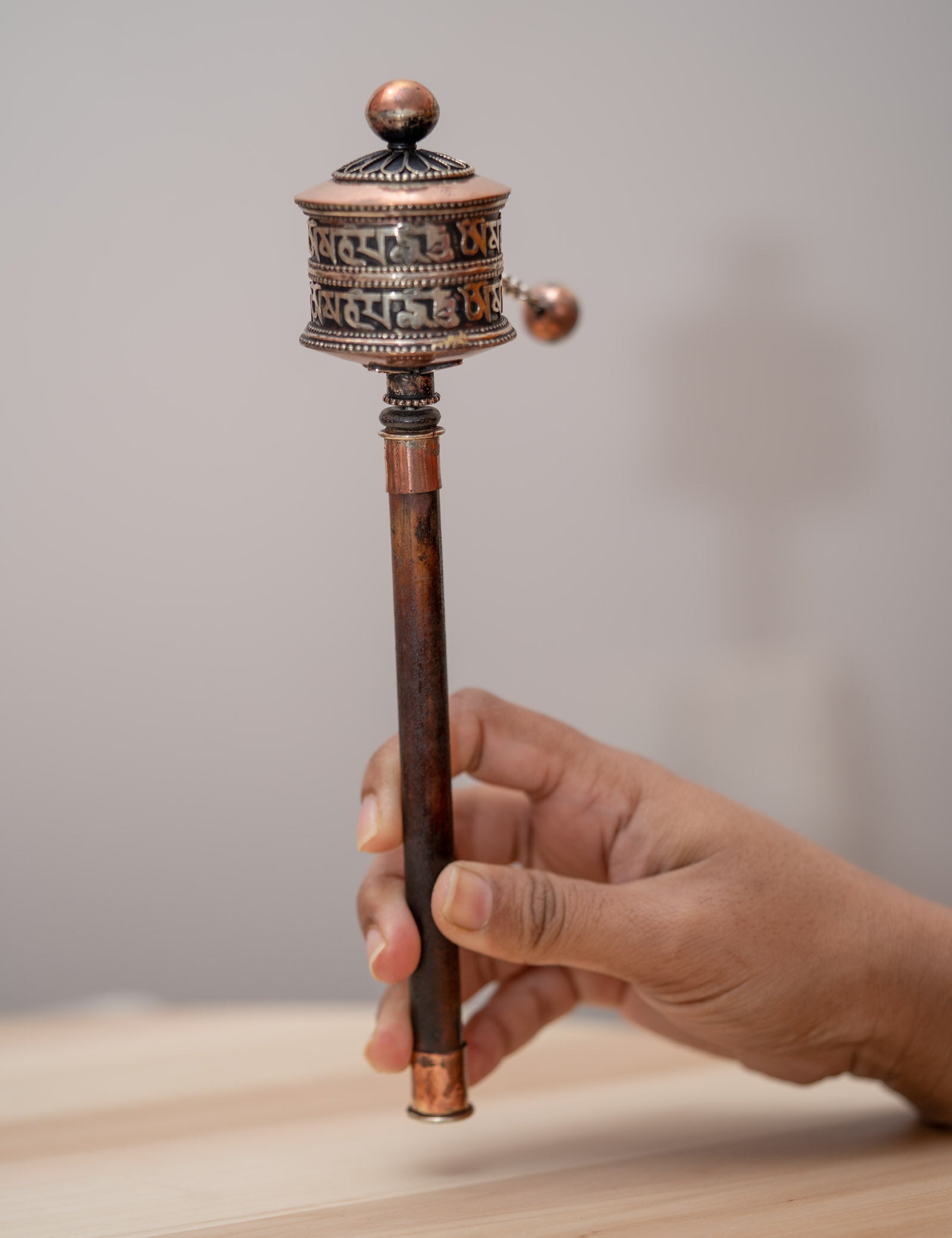 Wood handle prayer wheel for spiritual and religious routines.