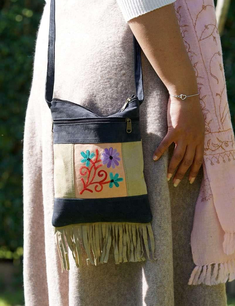 A small sling style, cross body bag with tassel/fringe at the bottom giving it a bohemian chic look.