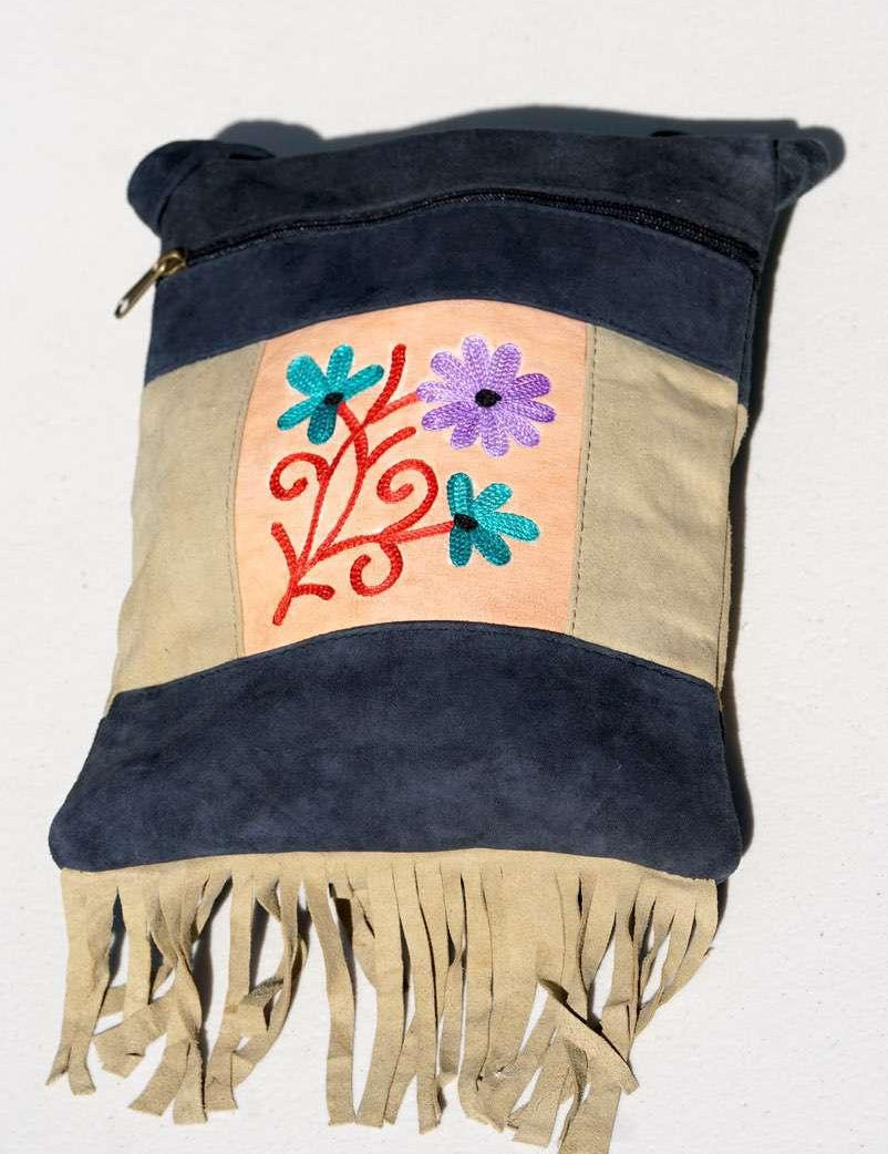 A small sling style, cross body bag with tassel/fringe at the bottom giving it a bohemian chic look.