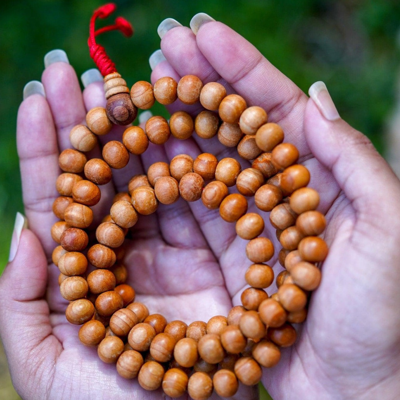 108 Beads Sandalwood Mala being held